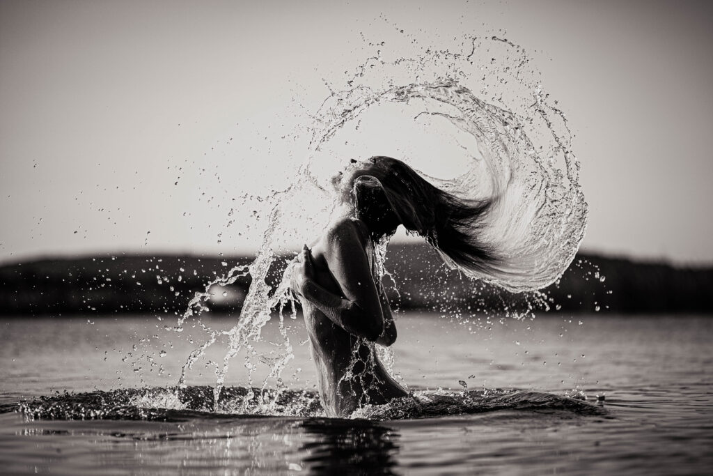 En la laguna la brava mujer se posa con el torso sin la parte superior d ela bikini y en una imagen en byn se ve como su cuerpo emerge del agua y salpicando gotas desde su cabello envuelve su cuerpo con el movimiento de la caida del agua